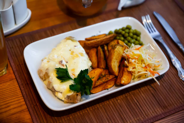 Appetizing French style meat in Mornay sauce served with vegetable garnish. Festive Russian cuisine