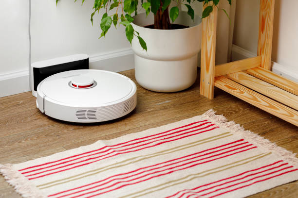 istock White robotic vacuum cleaner on wooden floor 1297380181