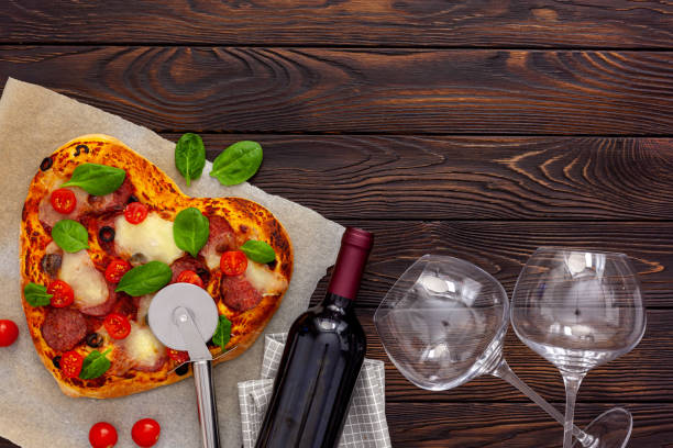 istock Heart pizza with a bottle wine, glasses and gift box 1297381637