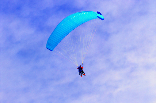 Skydiver flying over the beach.