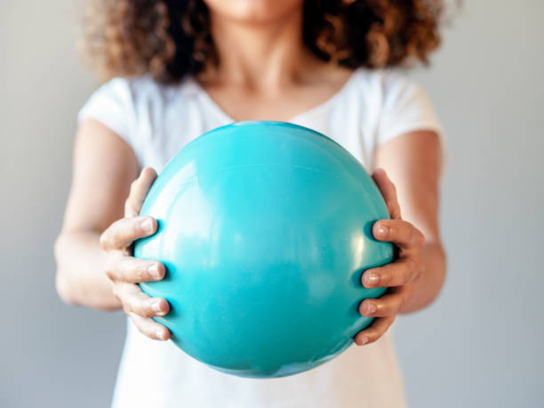 istock woman holding blue plastic ball 1297385258