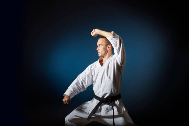 istock On a blue background with a gradient adult athlete performs formal karate exercises. 1297386553