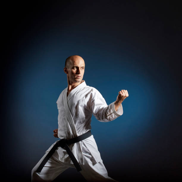 istock Athlete trains formal karate exercises on blue background with gradient 1297386557