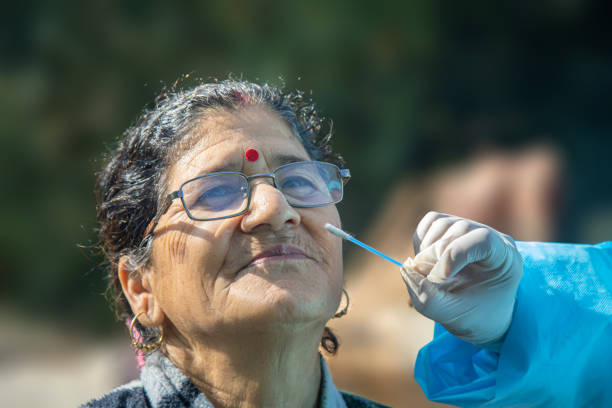 Medic taking sample for coronavirus testing in India Covid19 test in India, Medic wear PPE suits collects swab sample from the nose of a woman for COVID-19 test via Rapid Antigen, to curb the spread of coroavirus. village maharashtra stock pictures, royalty-free photos & images