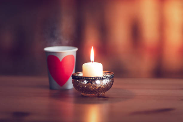 tazza di caffè con un cuore e una candela accesa - tea cup disposable cup tea sugar foto e immagini stock