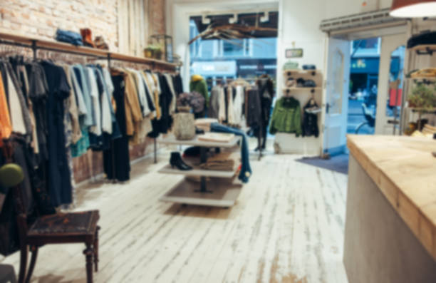 Interior of a small clothing store Blurred shot of a fashion store. Interior of a small clothing store with no people. designer clothing photos stock pictures, royalty-free photos & images