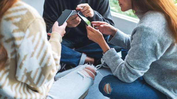 istock Group of young people using and looking at mobile phone together 1297389871