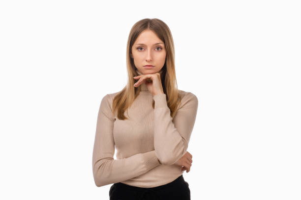 istock Pensive blond girl with thoughtful expression, keeps hand on chin, plans something or makes choice 1297391174
