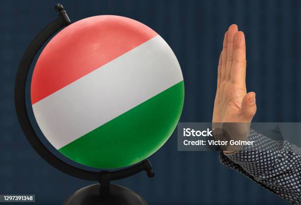 Gesture Of A Male Hand Warns Against The Globe Which Depicts A Colored National State Flag Hungarian Stock Photo - Download Image Now