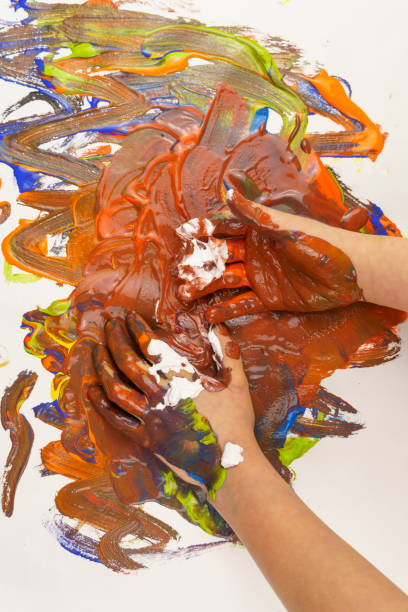 istock Children's hands are rubbing paint on a white background. 1297392864
