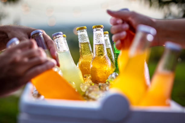 Grabbing ice cold beer bottles from a cooler Grabbing refreshing ice cold drinks bottles from cooler bag non alcoholic beverage photos stock pictures, royalty-free photos & images