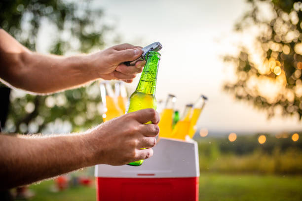 man opening beer bottle - human hand gripping bottle holding imagens e fotografias de stock