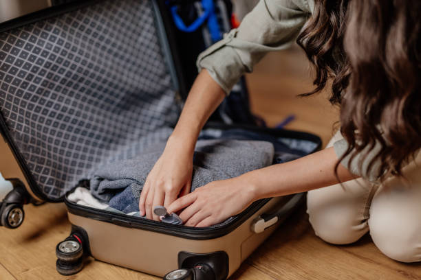 istock Woman arranging clothes in bag 1297393278