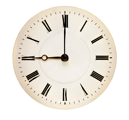 Antique clock face pointing at nine O'clock isolated against white background