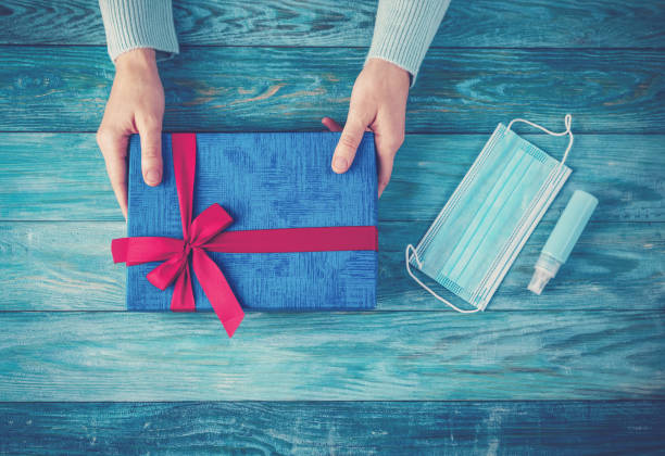 woman's hands holding present box. conceptual symbol of the christmas in pandemia of covid19. - solitude loneliness hardwood floor box imagens e fotografias de stock