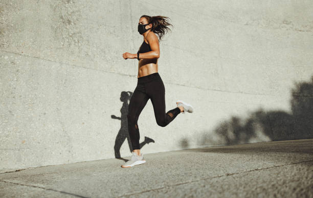 istock Sportswoman with face mask on morning run 1297395813