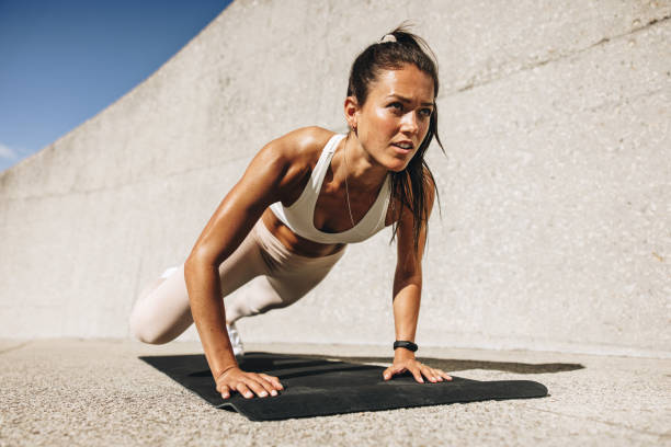 Fitness woman doing wide mountain climbers exercise Fitness woman doing wide mountain climbers exercise. Female in sportswear exercising on fitness mat outdoors. bodyweight training photos stock pictures, royalty-free photos & images