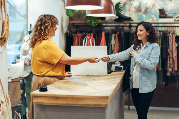 istock Female customer paying for the purchase at clothing store 1297398754