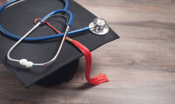 istock Graduation hat and stethoscope on the wooden background. 1297398850