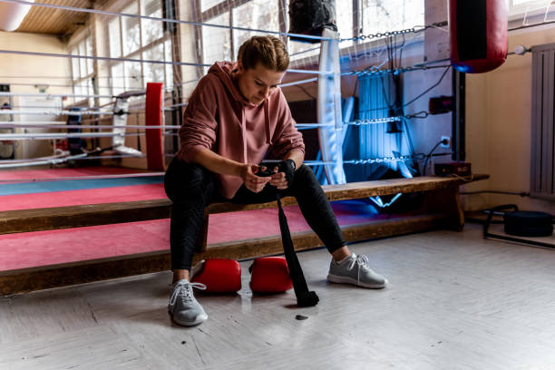 istock Female boxer sitting on bench at gym 1297401294