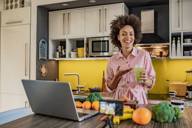 istock Female vlogger in the kitchen preparing healthy drink 1297402350