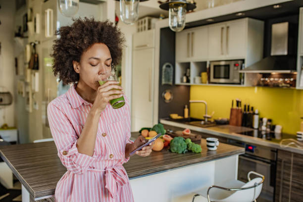 istock Woman is drinking smoothie in the kitchen 1297402504