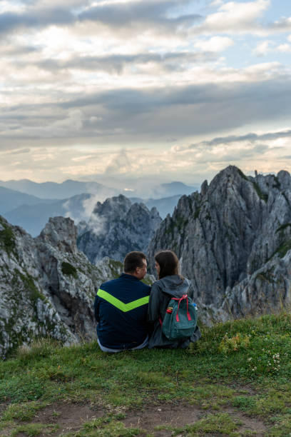 istock Young couple sitting on hill top 1297404092