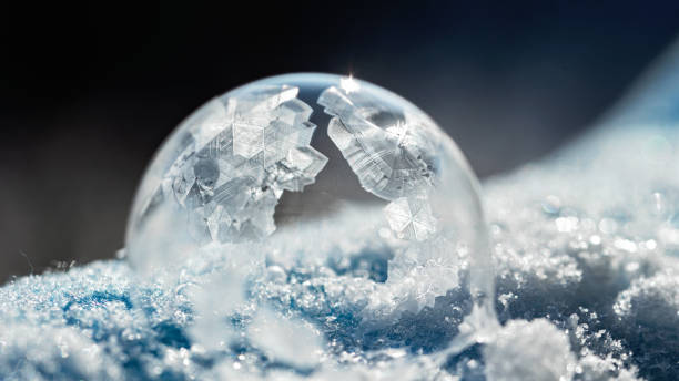 istock frozen bubble with bokeh background. Beautiful frosty patterns on frozen soap bubble 1297404199