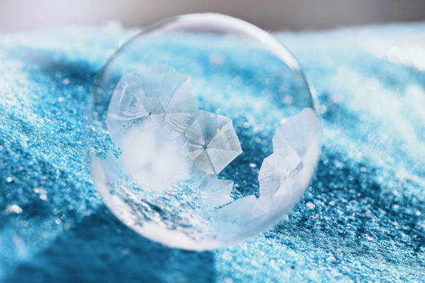 istock frozen bubble with bokeh background. Beautiful frosty patterns on frozen soap bubble 1297405116