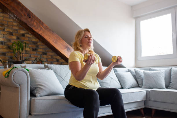 Mature Woman Is Exercising At Home And Using Cans Instead Of Weights