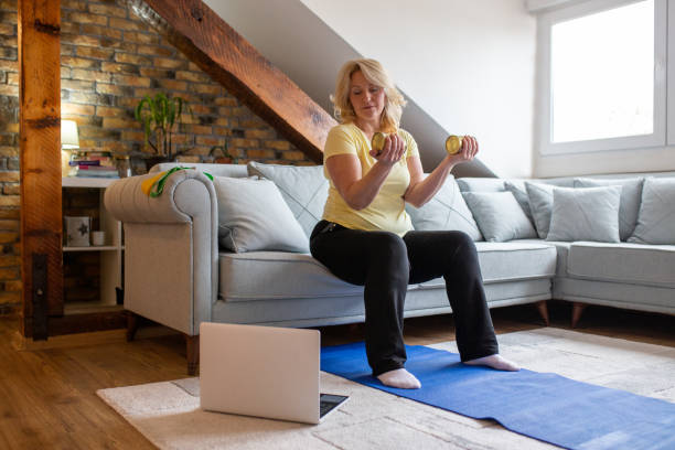 istock Mature Woman Is Exercising At Home And Using Cans Instead Of Weights 1297405839
