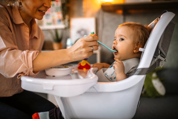 istock Mother feeding her little baby boy 1297406772