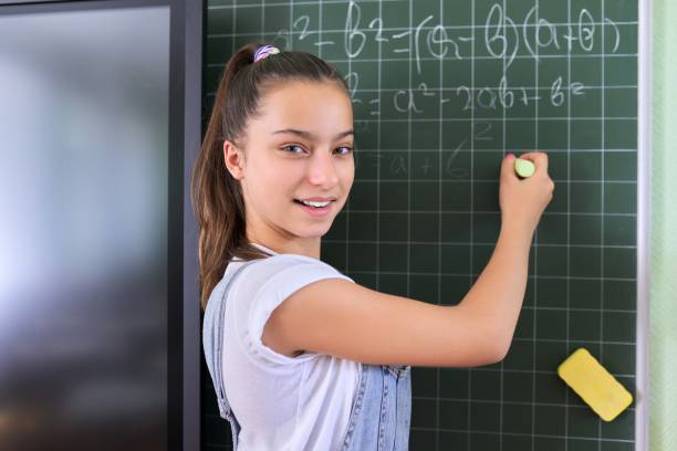 portrait of girl student of teenager 13 years old at school near chalk board - 13 14 years teenager school education imagens e fotografias de stock