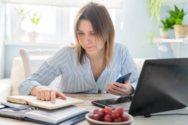 istock Female working from home with computer, books, phone 1297408155