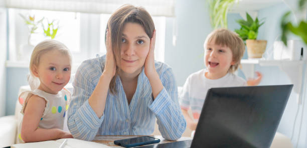 istock Female working from home with kids running and screaming 1297408171