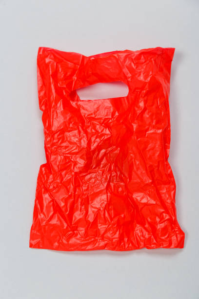 istock Clear red disposable plastic bag on gray background. Space for text 1297408576