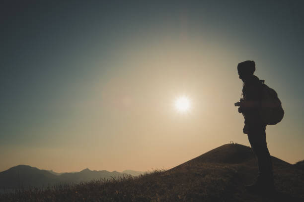 istock Young standing man with backpack. over sunset in nature 1297408586