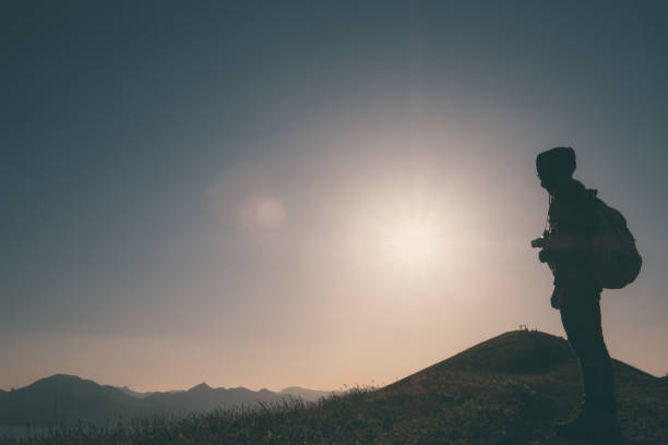 istock Young standing man with backpack. over sunset in nature 1297409563