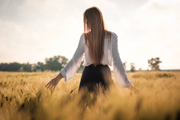 istock Red-haired girl in a wheat field at sunset. 1297411477