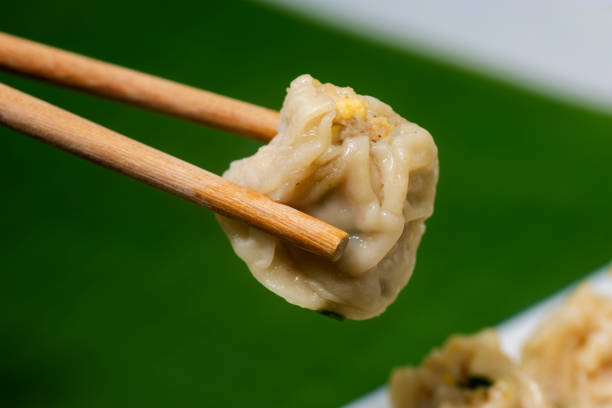 istock Cose-up of chopsticks dumplings on a plate 1297411508
