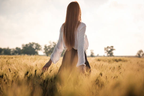 istock Red-haired girl in a wheat field at sunset. 1297411516