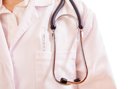 Close up of stethoscope and thermometer in pocket of doctor