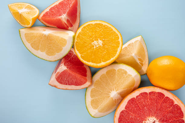 agrumi freschi. composizione agrumi e fetta su sfondo blu, copia spazio. vista dall'alto. motivo flatlay di agrumato arancio, limone, lime e fette di pompelmo sfondo. - citrus fruit frame portion isolated foto e immagini stock