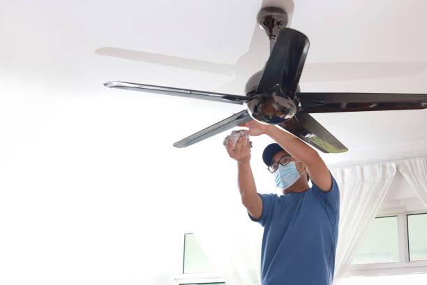 istock Asian man wearing a protective mask cleaning ceiling fan at home 1297414636