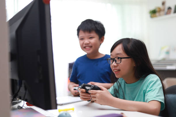 istock Happy siblings playing video game in living room. 1297414732