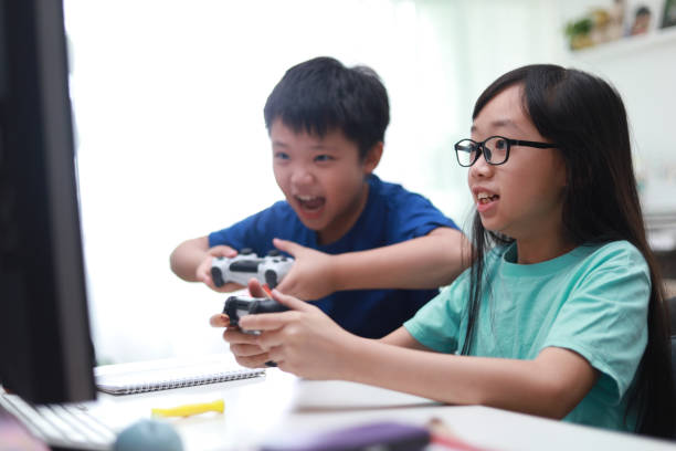istock Happy siblings playing video game in living room. 1297414783