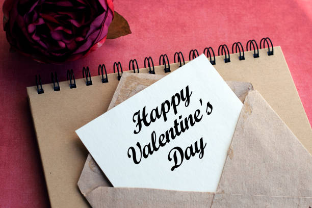 istock Vintage envelope with a white nameplate with an inscription on a pink background along with a flower. Natural light. Festive concept. The inscription is associated with Valentine's Day, Mother's Day or Women's Day. 1297414784