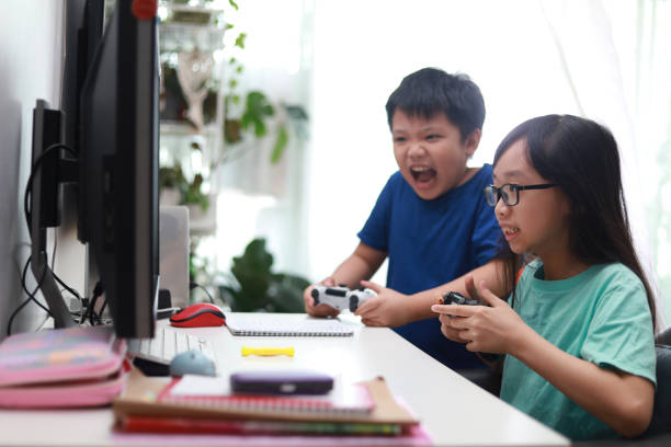 istock Happy siblings playing video game in living room. 1297414785