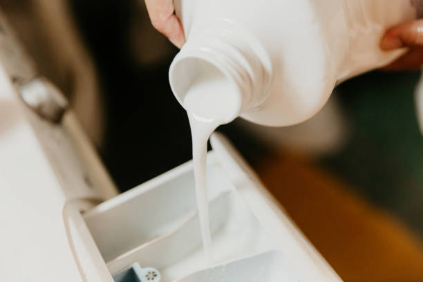 istock Pouring washing liquid in washing machine 1297415632