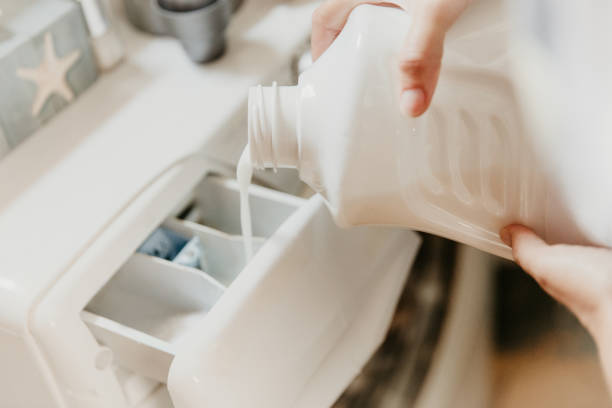 pouring washing liquid in washing machine - dishwashing detergent imagens e fotografias de stock